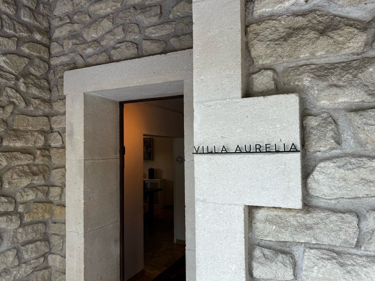 Custom metal sign displaying text in a sleek, modern font. Floating metal letters mounted on a light-colored textured background. Minimalist design suitable for home or business decor.