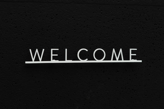 Custom metal sign displaying text in a sleek, modern font. Floating metal letters mounted on a textured background. Minimalist design suitable for home or business decor.