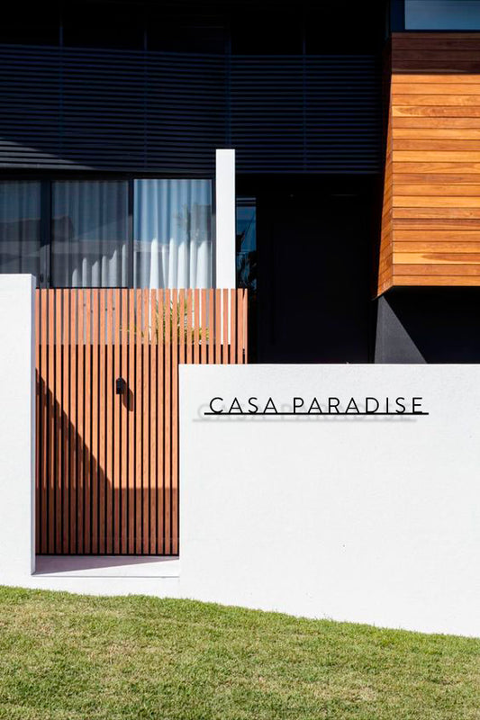 Custom metal sign displaying text in a sleek, modern font. Floating metal letters mounted on a light-colored textured background. Minimalist design suitable for home or business decor.