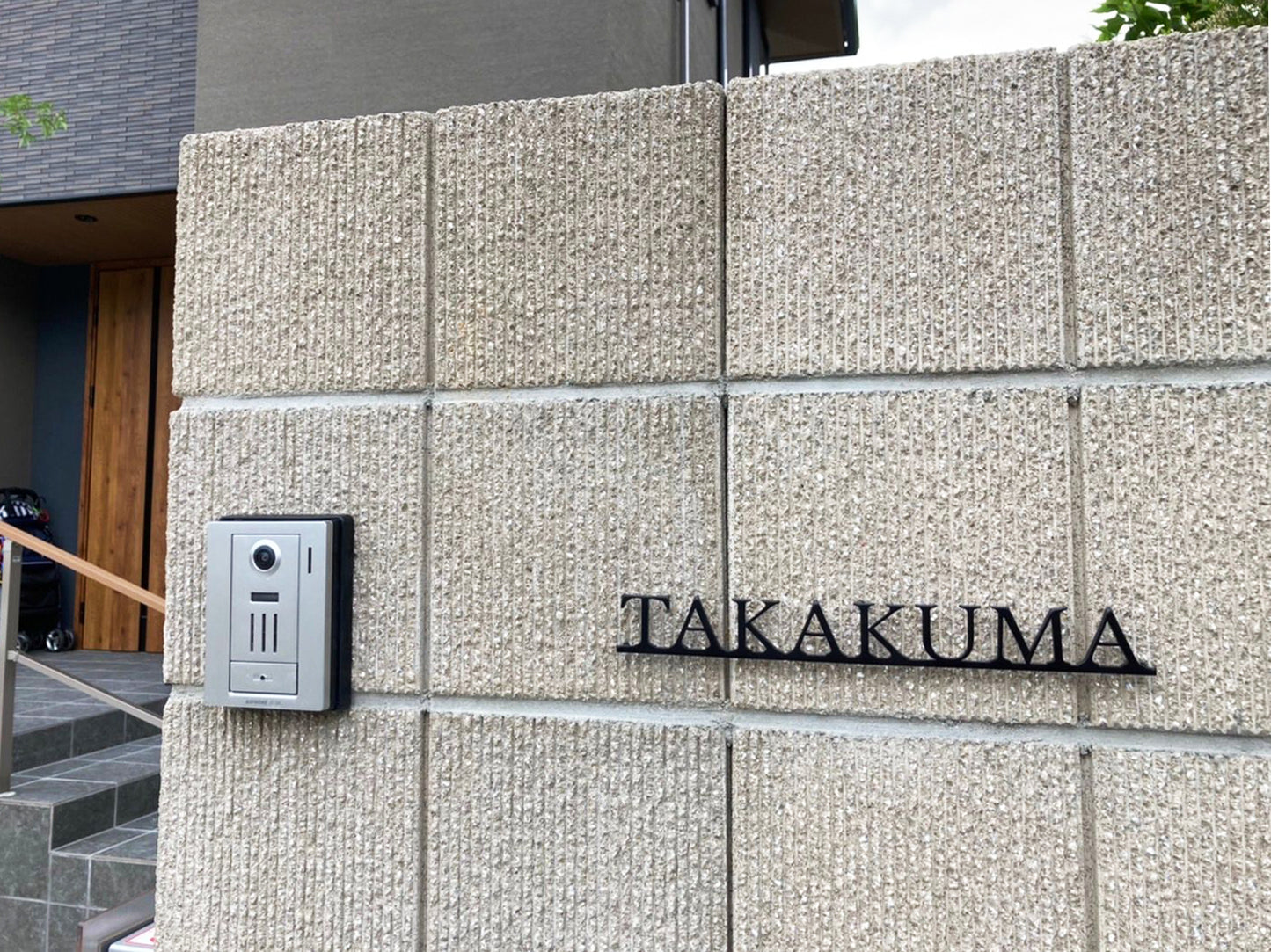 Custom metal sign displaying text in a sleek, modern font. Floating metal letters mounted on a light-colored textured background. Minimalist design suitable for home or business decor.