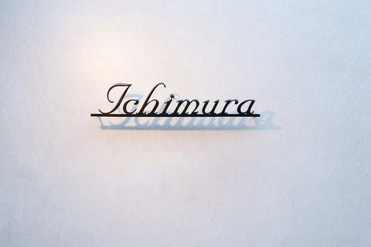 Custom metal sign displaying text in a sleek, modern font. Floating metal letters mounted on a light-colored textured background. Minimalist design suitable for home or business decor.