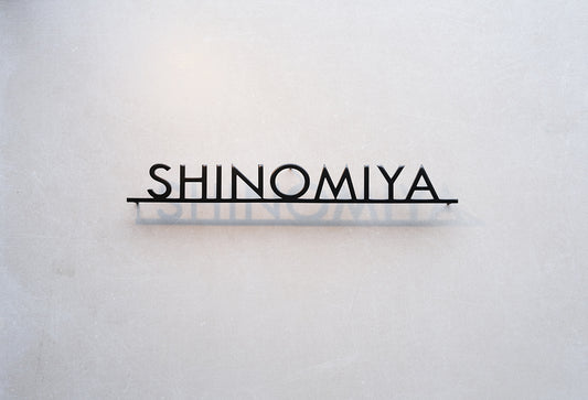 Custom metal sign displaying text in a sleek, modern font. Floating metal letters mounted on a light-colored textured background. Minimalist design suitable for home or business decor.