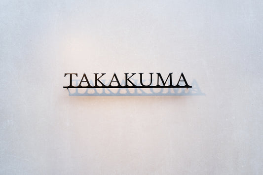 Custom metal sign displaying text in a sleek, modern font. Floating metal letters mounted on a light-colored textured background. Minimalist design suitable for home or business decor.