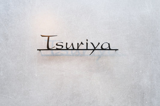 Custom metal sign displaying text in a sleek, modern font. Floating metal letters mounted on a light-colored textured background. Minimalist design suitable for home or business decor.