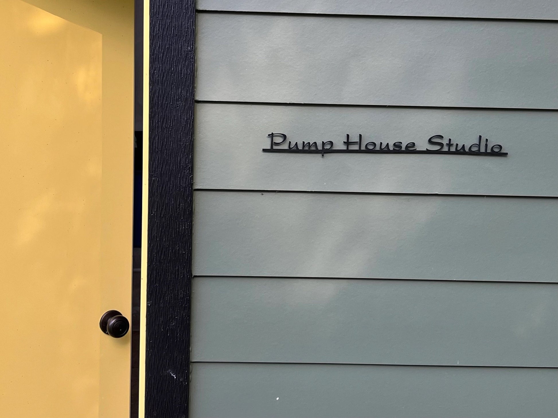 Custom metal sign displaying text in a sleek, modern font. Floating metal letters mounted on a textured background. Minimalist design suitable for home or business decor.