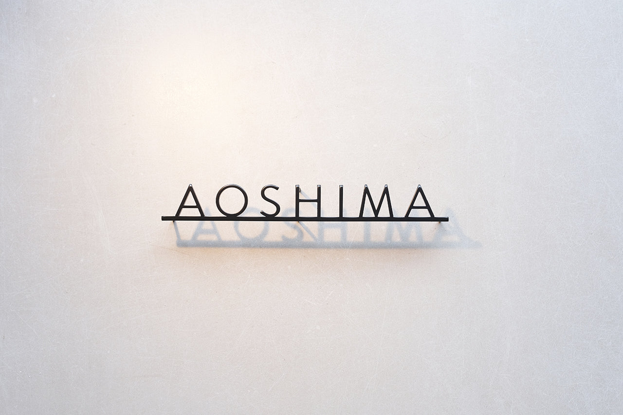 Custom metal sign displaying text in a sleek, modern font. Floating metal letters mounted on a light-colored textured background. Minimalist design suitable for home or business decor.